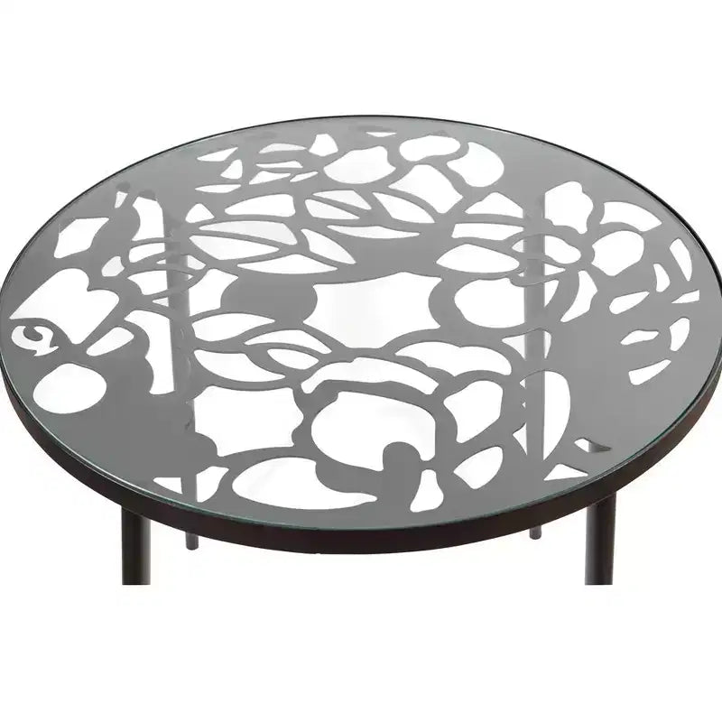 LeisureMod Devon 5-Piece Outdoor Dining Set - Round Glass Table with 4 Black Flower Design Stackable Chairs