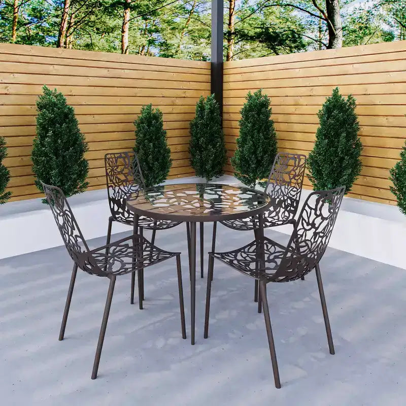LeisureMod Devon 5-Piece Outdoor Dining Set - Round Glass Table with 4 Black Flower Design Stackable Chairs